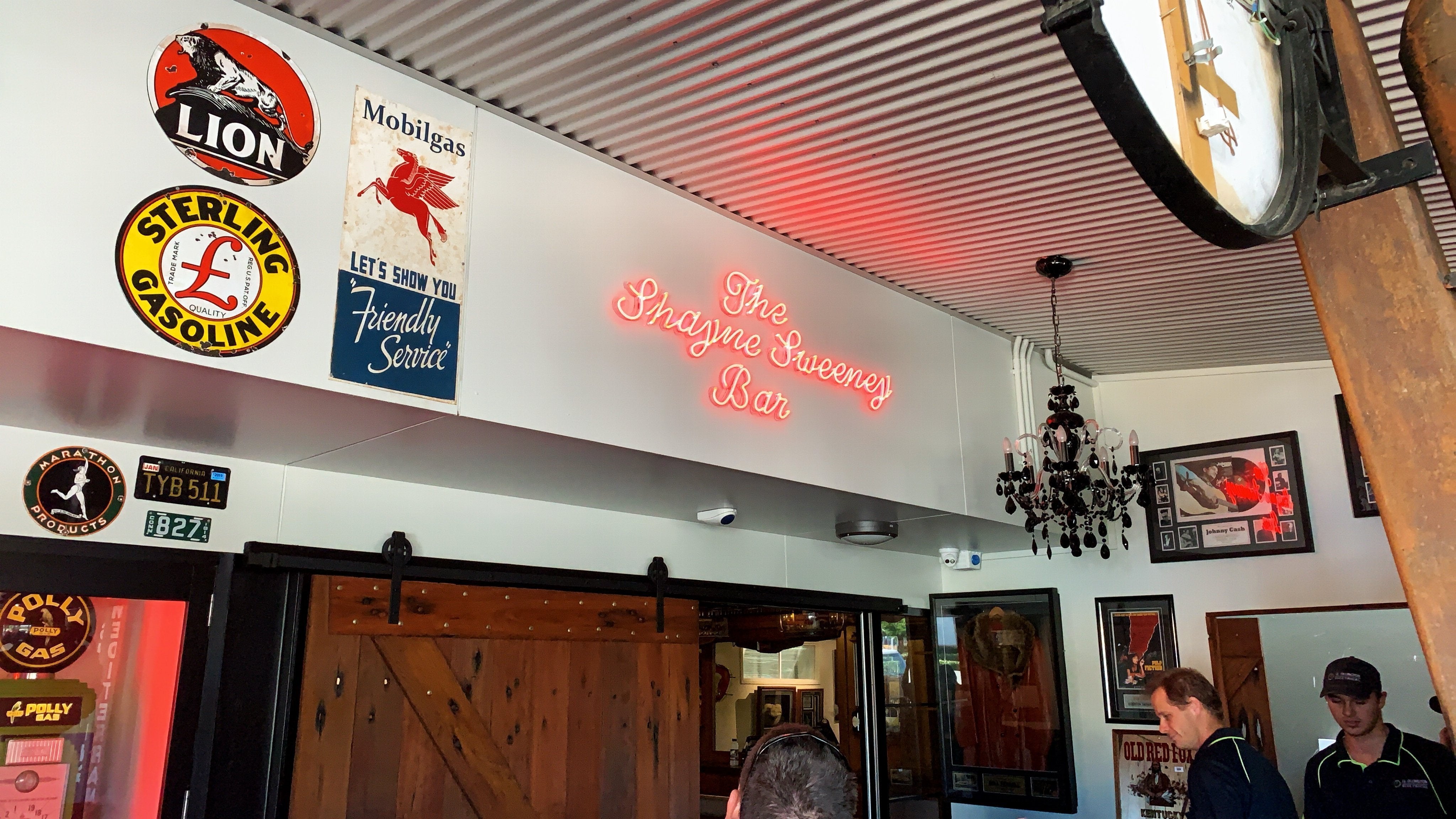 A bright red neon sign above a bar entrance| Neon Signs