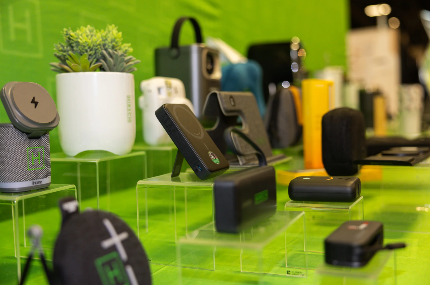 Branded tech items including a portable charger and speaker are dispalyed at a convention.