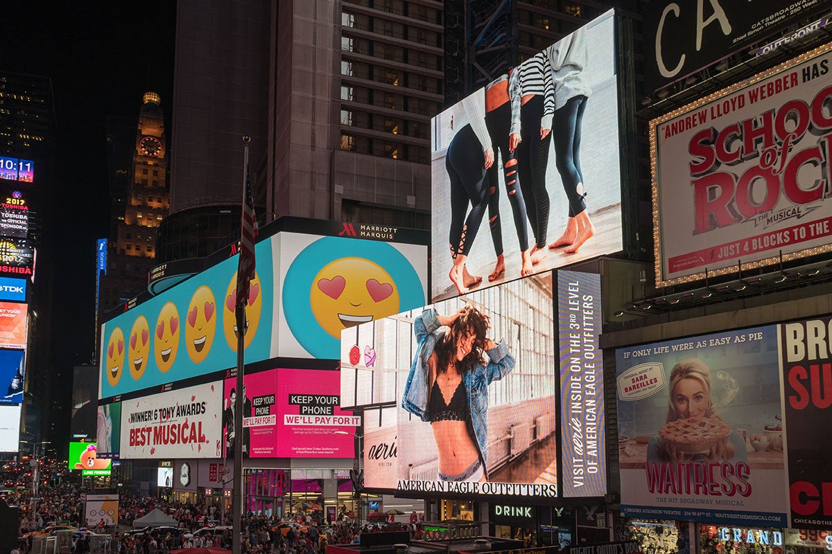 Digital billboards and LED signs lighting up a city street